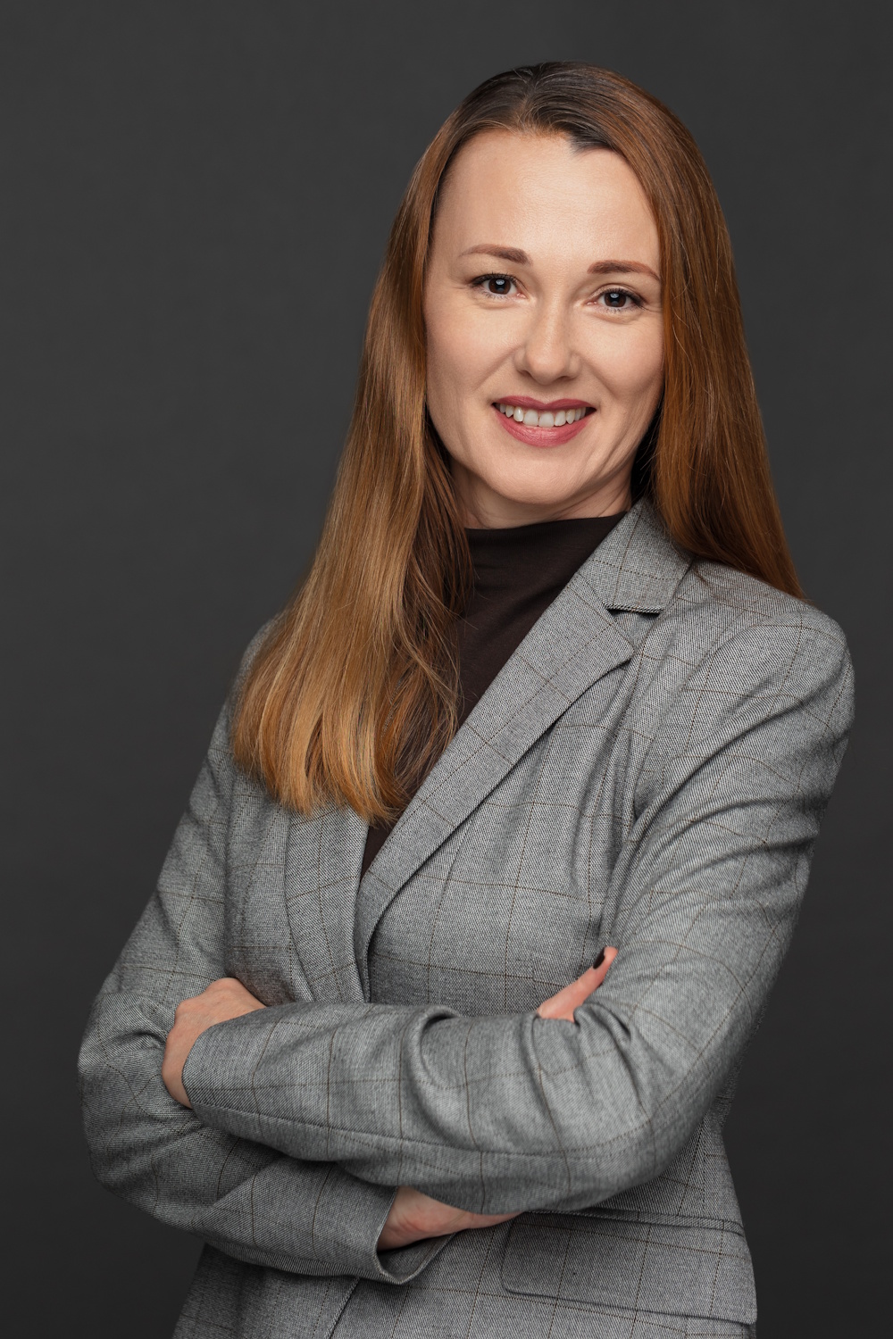 Aneliya Majdanac, die Hände verschränkt, im hellgrauen Business-Outfit