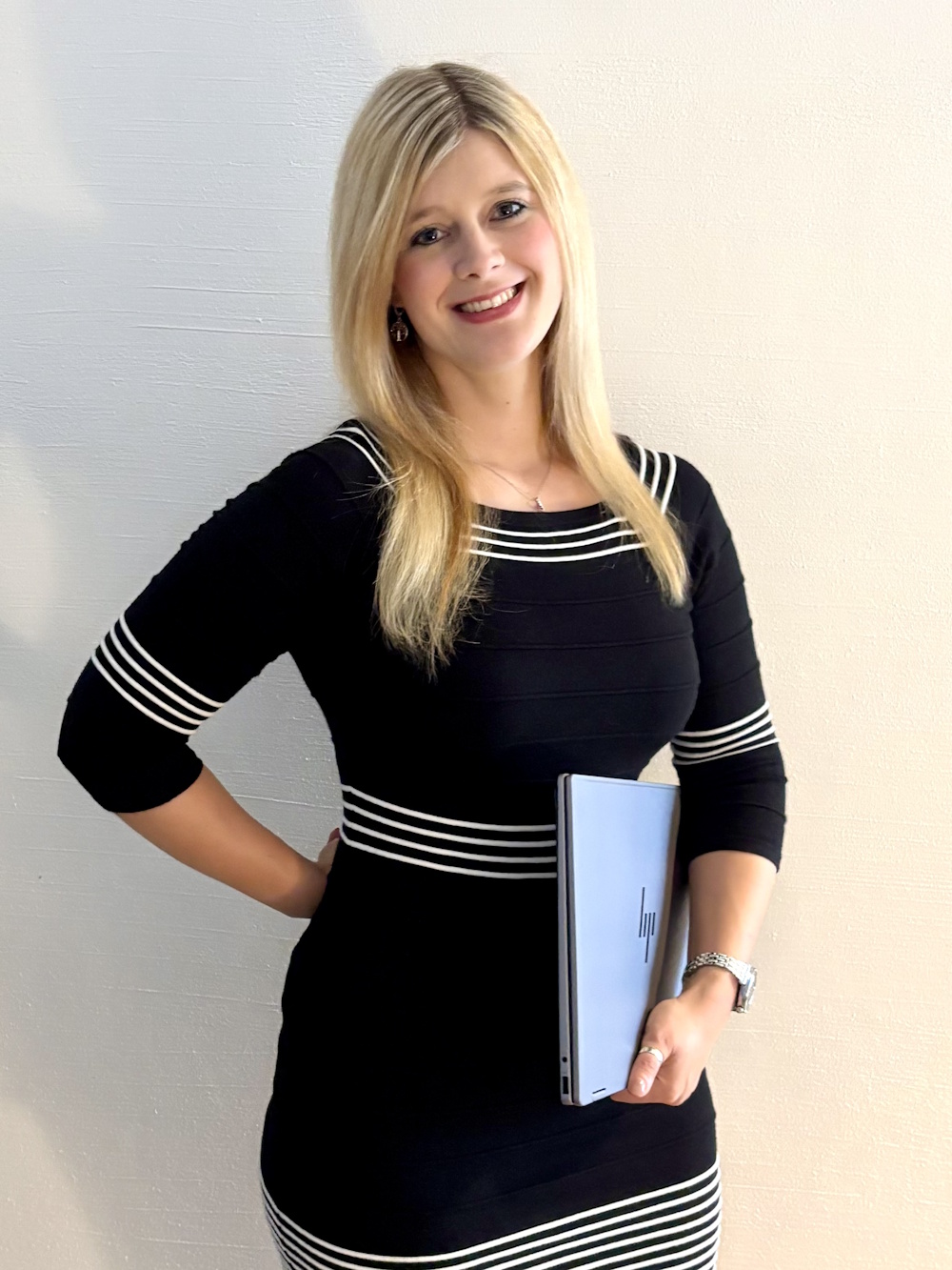 Susanne Schneider stehend mit einem Notebook unterm linken Arm